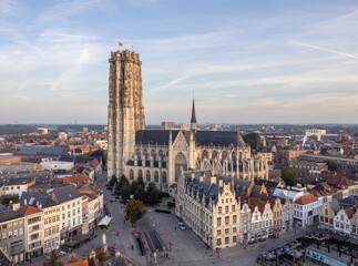 Aerial drone shot of Mechelen Saint Rumbold's Cathedral Sint Rombouts toren in a lovely morning light while birds are flying around