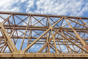 Railway transport bridge made of steel piles and beams against blue sky
