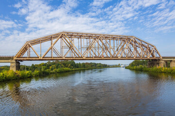 Naklejka premium Railway transport bridge made of steel piles and beams against blue sky
