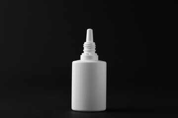 Bottle of nasal spray on black background