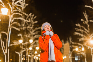 Portrait of young funny attractive woman over snowy Christmas background. Winter holidays and season concept.