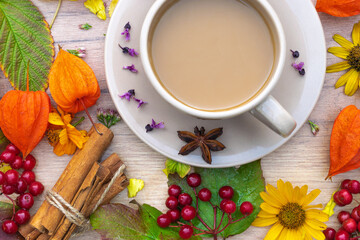 autumn composition cup of coffee on a table with flowers and leaves, top view, background picture

