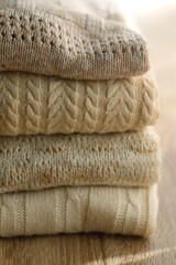 Pile of beige sweaters. Selective focus.