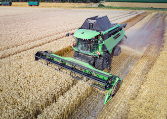 Getreideernte - Luftbild, moderner Mähdrescher beim Dreschen auf einem Getreidefeld.