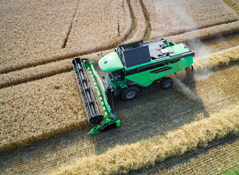 Getreideernte - Luftbild, moderner Mähdrescher beim Dreschen auf einem Getreidefeld.