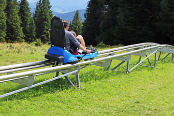Father and son enjoying a summer fun roller alpine coaster ride