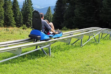 Foto op Canvas Father and son enjoying a summer fun roller alpine coaster ride © smuki