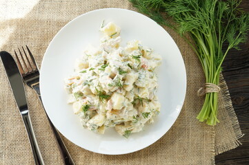 Traditional German potato salad with cucumber and mayonnaise.
