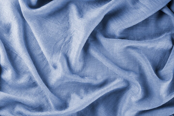 Fototapeta premium Close-up of bright yellow draped lightweight fabric as background. Selective focus.