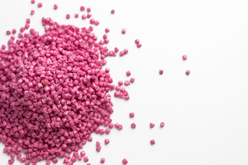 Pink granules of polypropylene or polyamide on a white background. Plastics and polymers industry....
