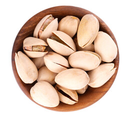Pistachio nuts, isolated in wooden bowl, on white background. Salted roasted pistachios. Top view.