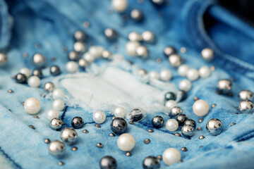 Jeans background clothing. Denim fabric closeup. Textures of clothing made of fabric with fashionable embroidery of pearl beads. Copy space for text. Fashionable style.