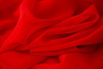 Obraz premium Red chiffon or silk material. Satin fabric close up background and texture with place for text. blurred background.