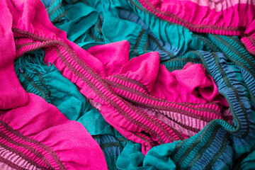 Knitted fabric surface as a background, winter scarves, warm plaid. Beautiful bright autumn clothes. Sewing and knitting.