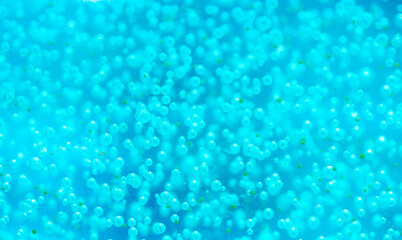 Liquid with bubbles. Close-up blue body scrub, particles of exfoliating ingredients, bubbles. Shower gel, cleansing the face and body. Spa treatments, skin care.
