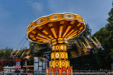 a bright carousel spins rapidly in the air at sunset
