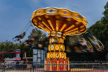 a bright carousel spins rapidly in the air at sunset