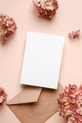 Invitation or greeting card mockup with envelope and pink hydrangea flowers decorations.