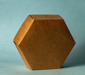 A hexagonal cardboard box, isolated on a blue background.