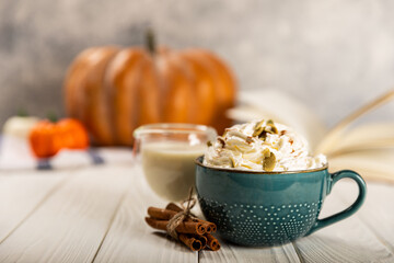 delicious hot, aromatic latte with pumpkin and cinnamon in a blue cup, on a white background with a tree.