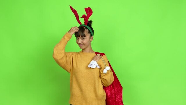 Young woman with christmas hat having doubts while scratching head over isolated background. Green screen chroma key