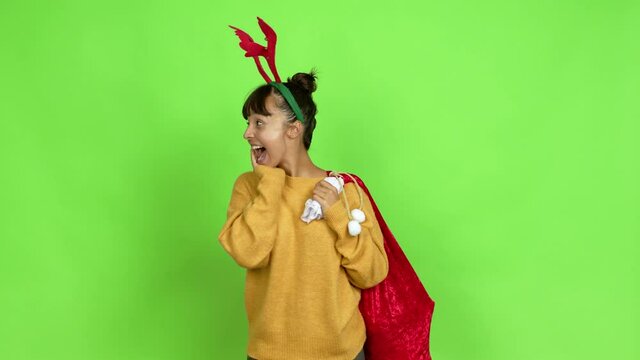 Young woman with christmas hat with surprise and shocked facial expression over isolated background. Green screen chroma key
