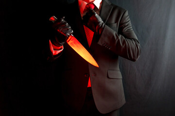 Portrait of Man in Dark Suit and Leather Gloves Holding Bloody Red Knife on Black Background. Mafia...