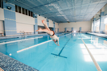 A young athlete trains and prepares for swimming competitions in the pool. Healthy lifestyle.