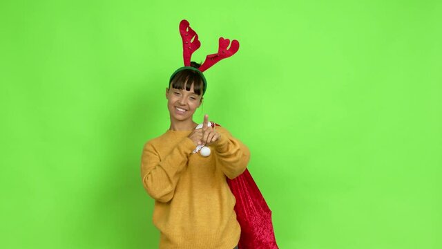 Young woman with christmas hat showing and lifting a finger in sign of the best over isolated background. Green screen chroma key