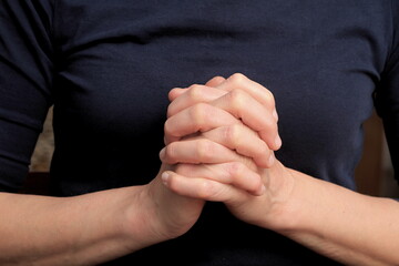 hands praying together on black background  stock photo