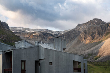 Residential building in front of a mountain with a glacier in summer
