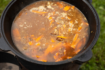 Soup in a pot. Food outside. Cooking soup on an open fire.