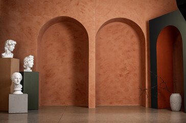 Two orange arches and three white busts. Indoors