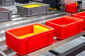 Plastic red box on roller line for tranfer production part in prodine lin in factory, production,...