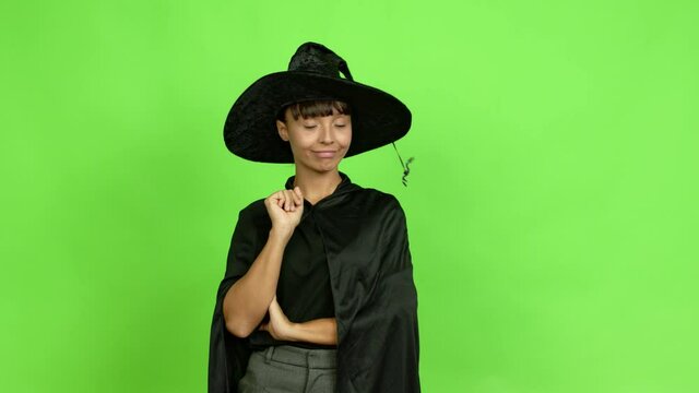 Young woman wearing witch hat for halloween parties doing NO gesture over isolated background. Green screen chroma key