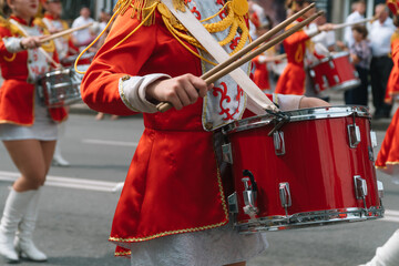Street performance. Close-up of female drummers hands in red vintage uniform at the parade