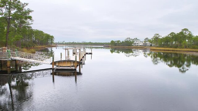 Landscape nature view on Western lake park by Gulf of Mexico in Seaside, Florida on cloudy weather with wharf boathouse marina boardwalk dock ramp