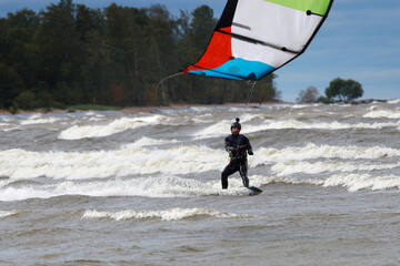 Kite surfer glides on sea waves
