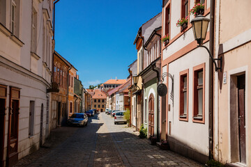 Fototapeta na wymiar Trebic, Bohemia, Czech Republic, 06 July 2021: Narrow picturesque street with colorful buildings in historic center in medieval city, renaissance and baroque historical buildings at summer sunny day