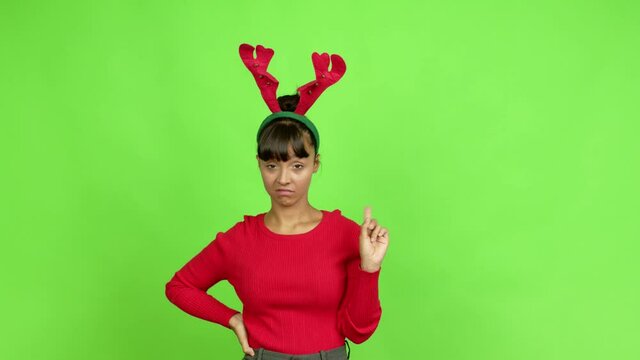 Young woman wearing christmas hat doing NO gesture over isolated background. Green screen chroma key