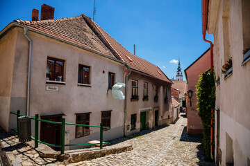 Trebic, Bohemia, Czech Republic, 06 July 2021: Narrow picturesque street with colorful buildings in historic center in medieval city, renaissance and baroque Jewish quarter at summer sunny day