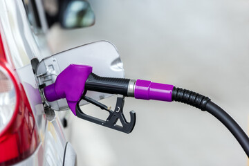 Silver car refuelling at the gas station, the concept of fuel energy