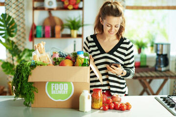 smiling young 40 years old woman with food box in kitchen