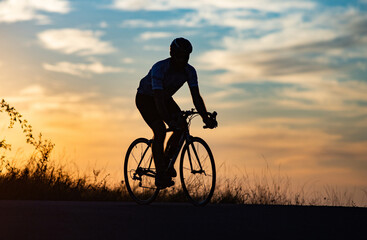 Obraz premium cyclist silhouette at sunset sports and fitness concept