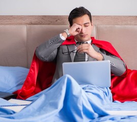 Super hero businesswoman working in bed