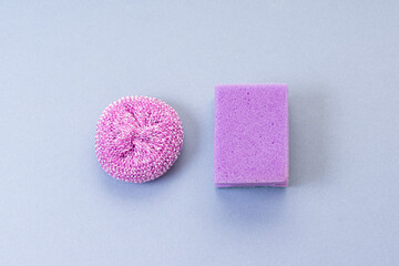 Steel wool sponge and ordinary purple sponge on blue background. Set for washing dishes. Top view