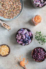 Assortment of beans and lentils on concrete background. The concept of healthy and nutritious food. Vegan high protein product. Top view.