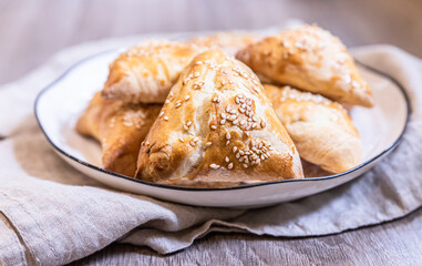 Puff pastry buns with pumpkin sprinkled with sesame seeds. Homemade autumn pastries.