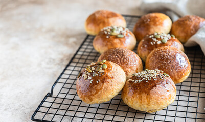 Fresh homemade pumpkin buns with brown sugar or seeds, light concrete background. Autumn bakery.