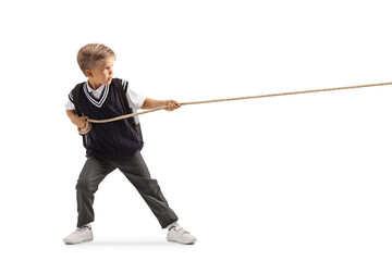 Full length profile shot of an angry schoolboy pulling a rope